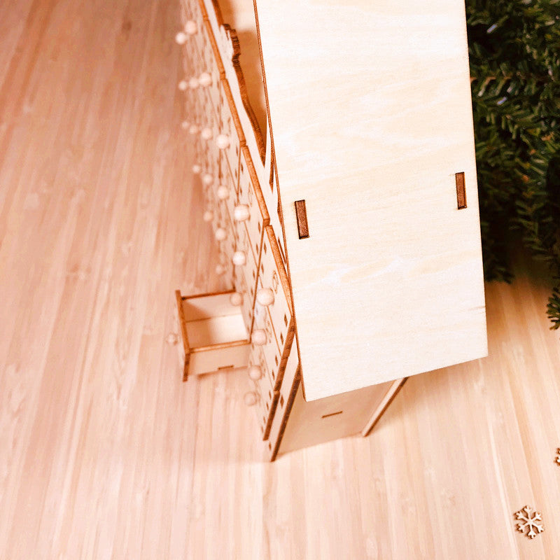 Calendrier de l'avent en bois posé sur un meuble