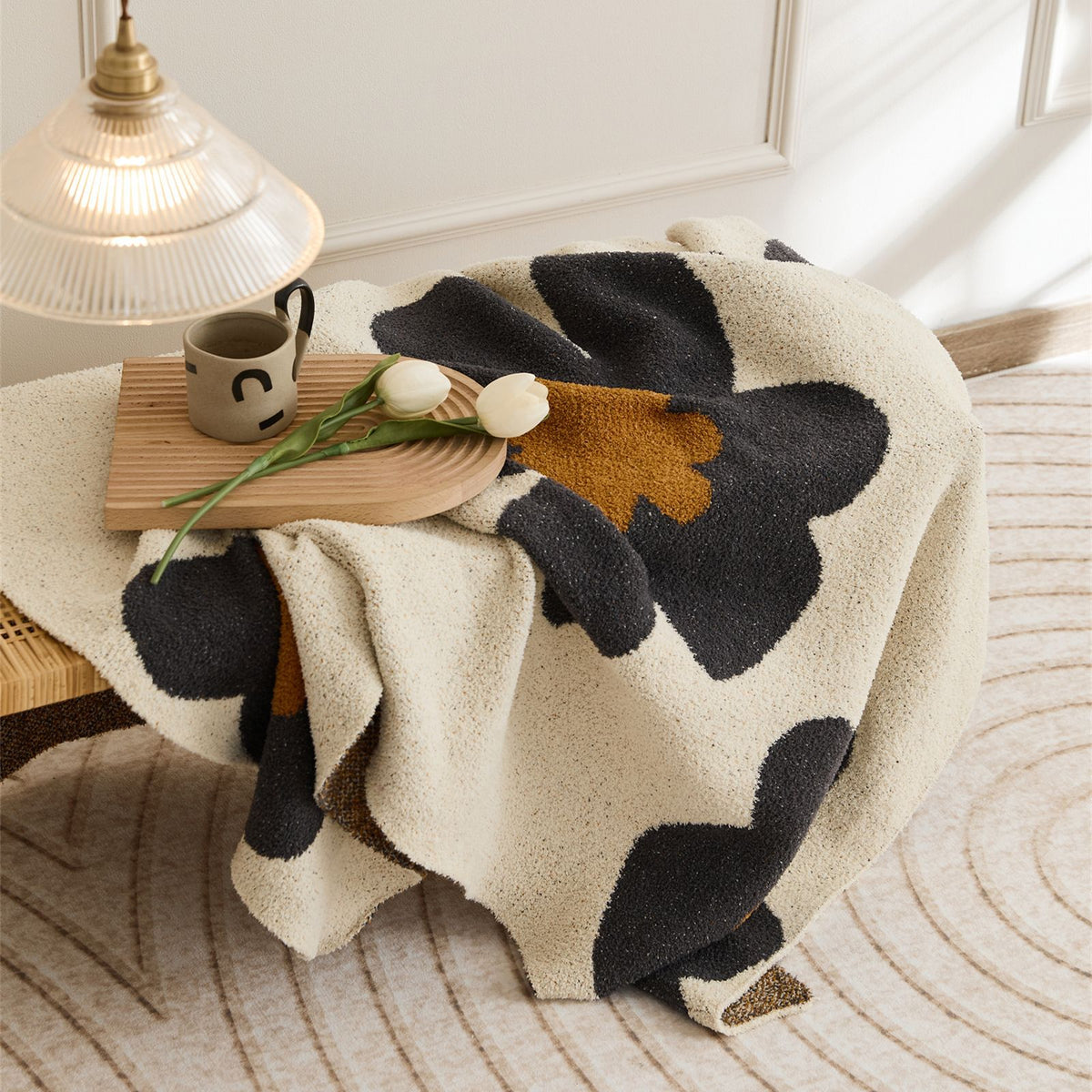 Plaid Fleur gris drapé sur un fauteuil